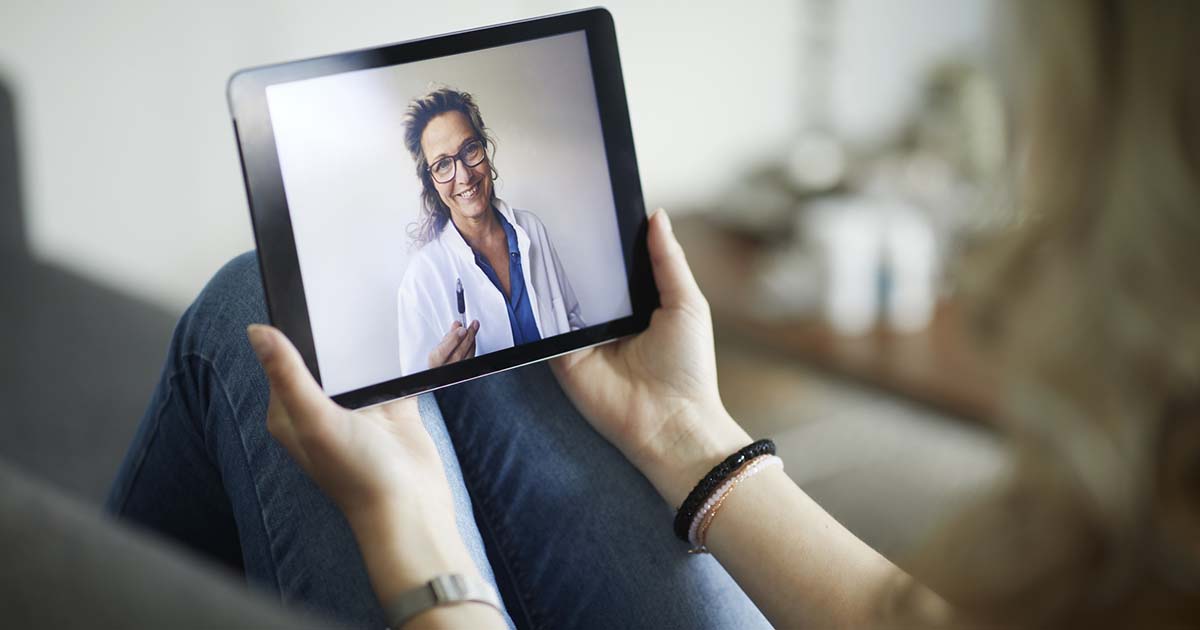 Female doctor on tablet for a telehealth visit Female doctor on tablet for a telehealth visit
