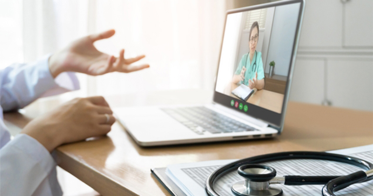 clinician hands and laptop open to a telehealth call clinician hands and laptop open to a telehealth call