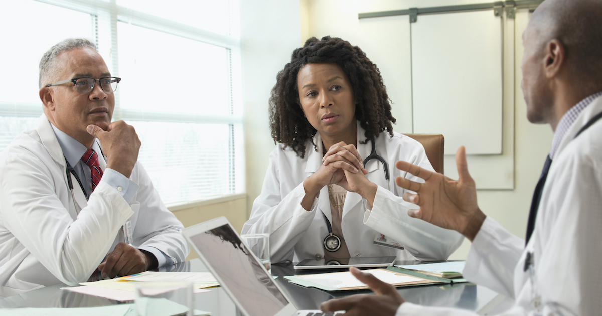 Doctors and informatics leaders speak at a table Doctors and informatics leaders speak at a table
