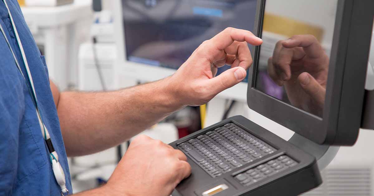 Healthcare worker using touchscreen computer terminal Healthcare worker using touchscreen computer terminal