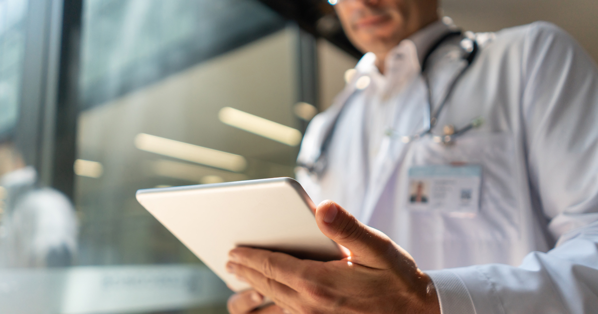 A doctor reviewing a patient's file on a digital tablet A doctor reviewing a patient's file on a digital tablet