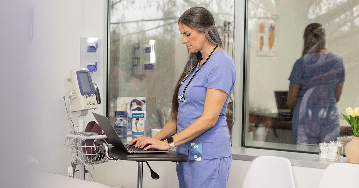 Healthcare worker using laptop in hospital room Healthcare worker using laptop in hospital room