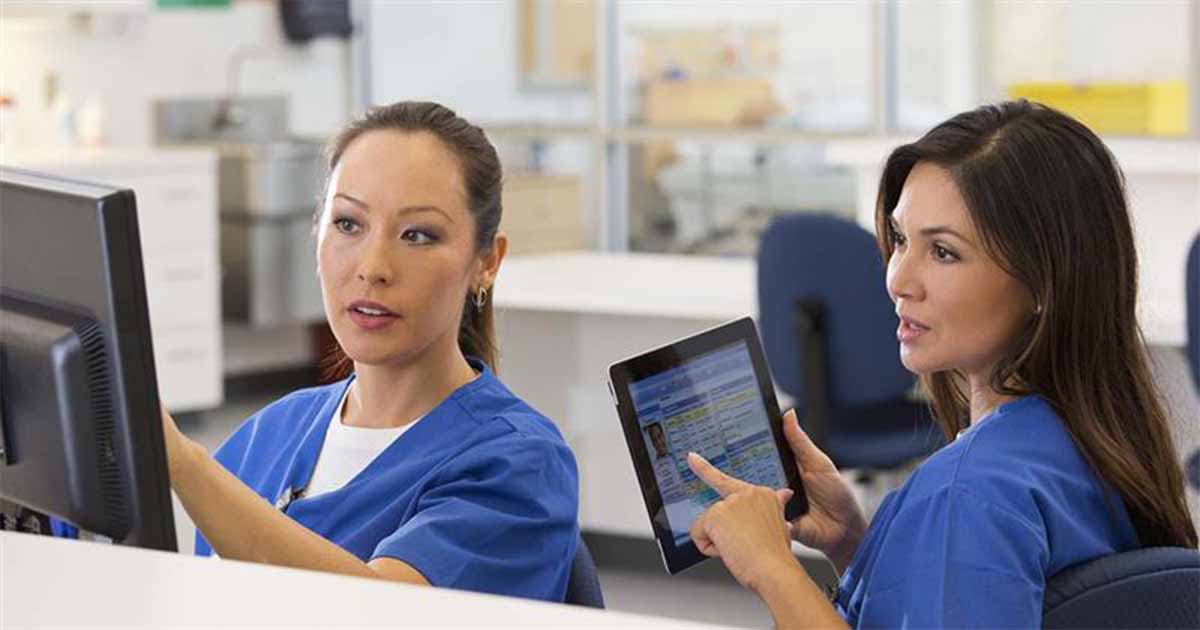 Nurses talking and pointing at device screens Nurses talking and pointing at device screens