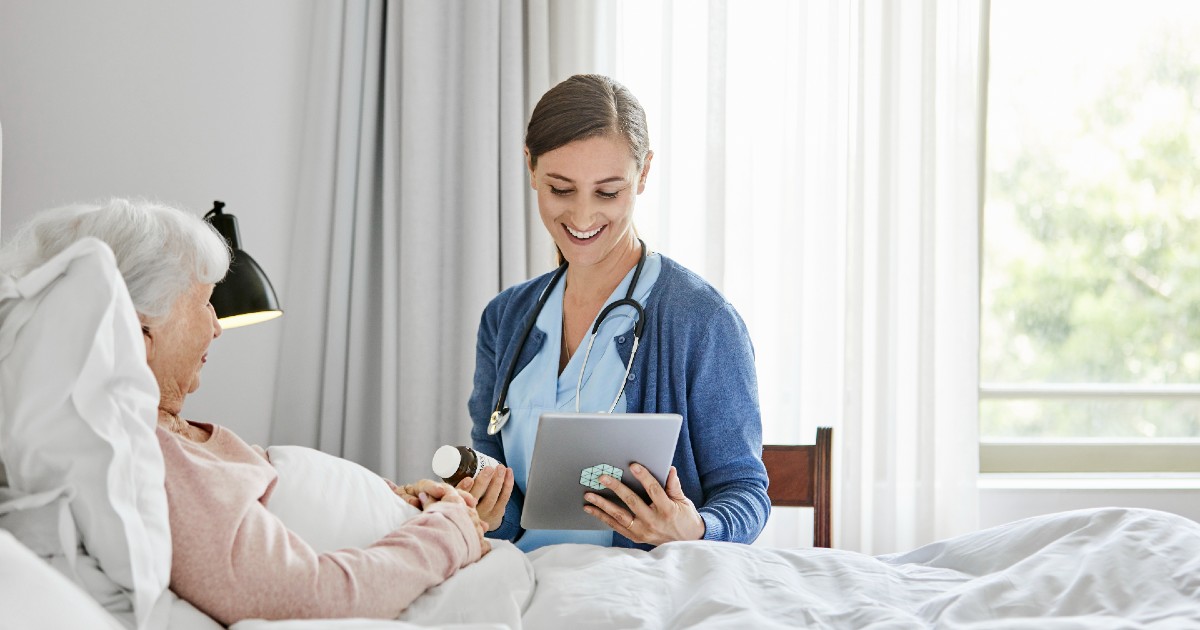 caregiver at patient bedside reviews prescription information with a virtual care prescriber on a tablet caregiver at patient bedside reviews prescription information with a virtual care prescriber on a tablet