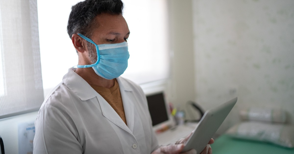 Nurse checks her tablet Nurse checks her tablet