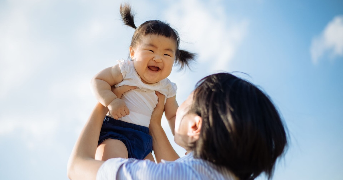 Person holding child in the air Person holding child in the air