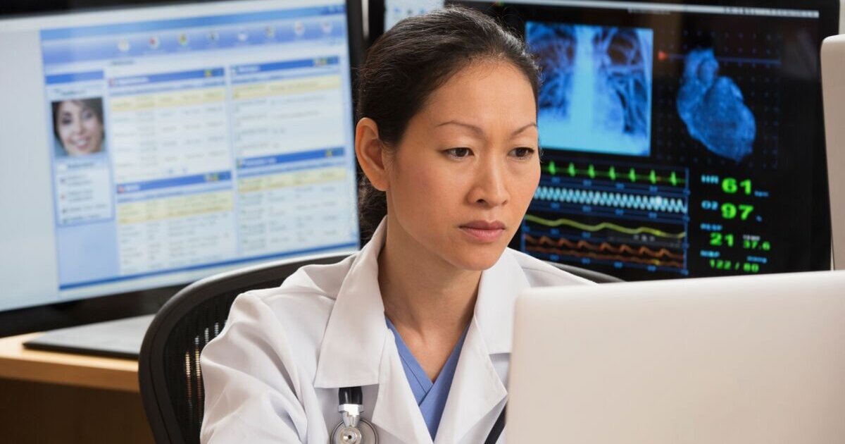 female doctor reviews patient data on multiple screens female doctor reviews patient data on multiple screens