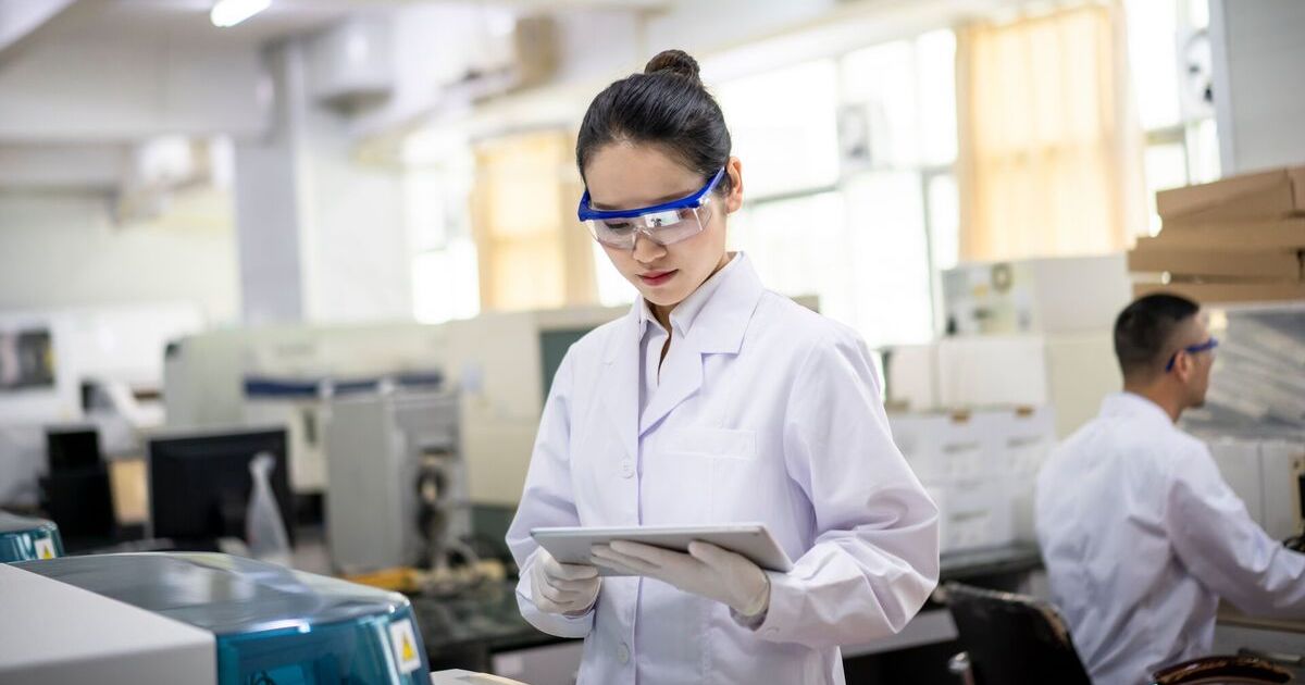 A lab scientist reviewing data in a digital tablet