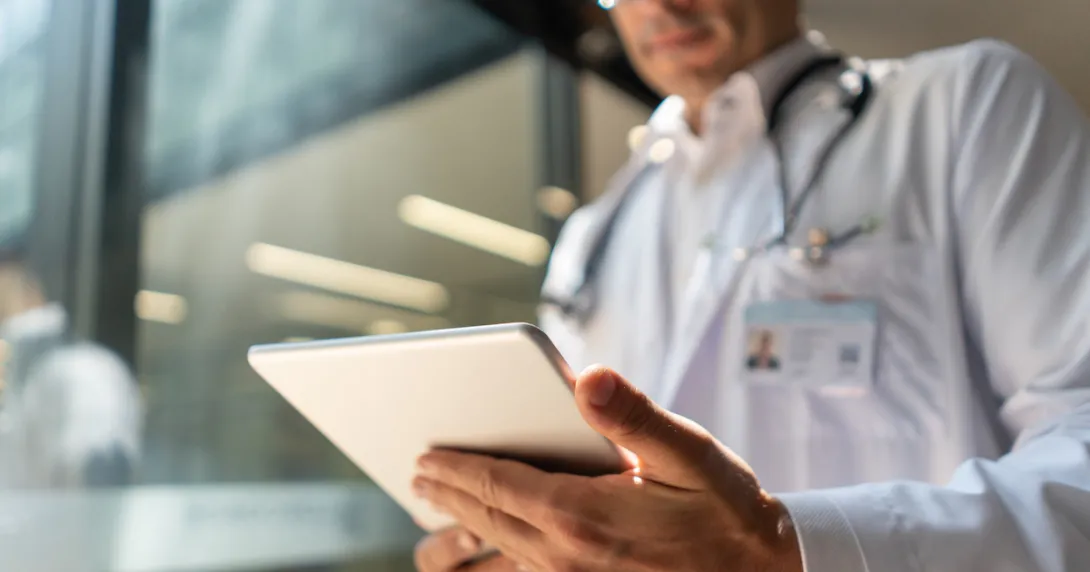 A doctor reviewing a patient's file on a digital tablet A doctor reviewing a patient's file on a digital tablet