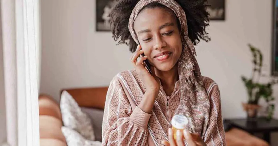 Person on the phone holding pill bottle Person on the phone holding pill bottle