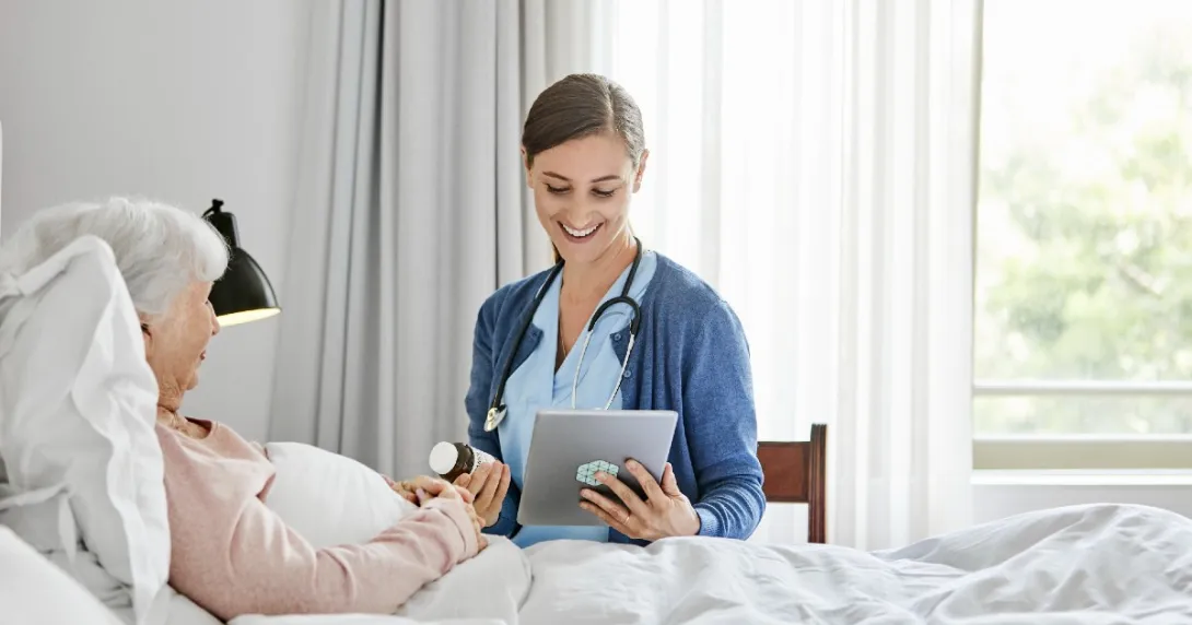 caregiver at patient bedside reviews prescription information with a virtual care prescriber on a tablet caregiver at patient bedside reviews prescription information with a virtual care prescriber on a tablet