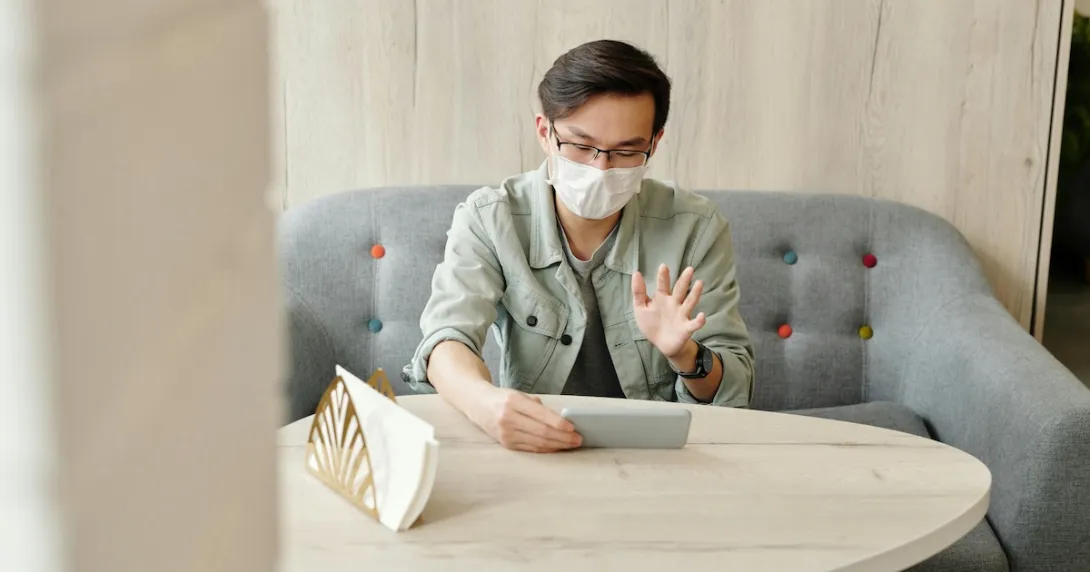 A patient wearing mask at home in an online consultation. A patient wearing mask at home in an online consultation.