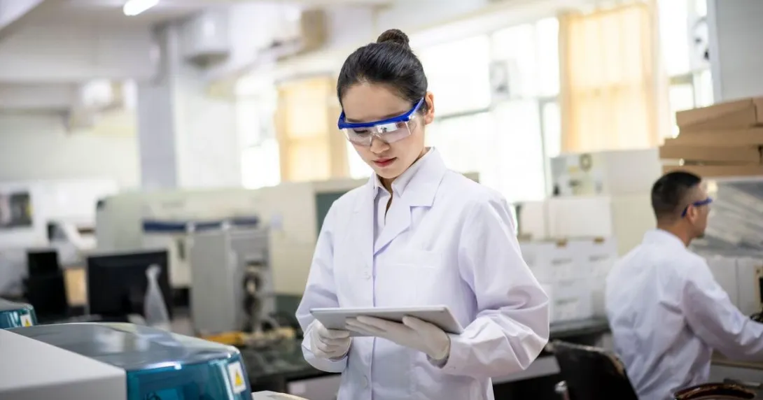 A lab scientist reviewing data in a digital tablet A lab scientist reviewing data in a digital tablet
